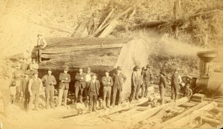 TWO PHOTOGRAPHS OF LUMBERJACKS AND LUMBERING, PROBABLY IN NORTHERN CALIFORNIA: LUMBERJACKS POSING WITH THEIR EQUIPMENT IN FRONT OF A TREE THEY ARE FELLING and A LARGE GROUP OF MEN POSING IN FRONT OF A LARGE LOG AND A STEAM DONKEY [titles supplied]. Albumen prints.